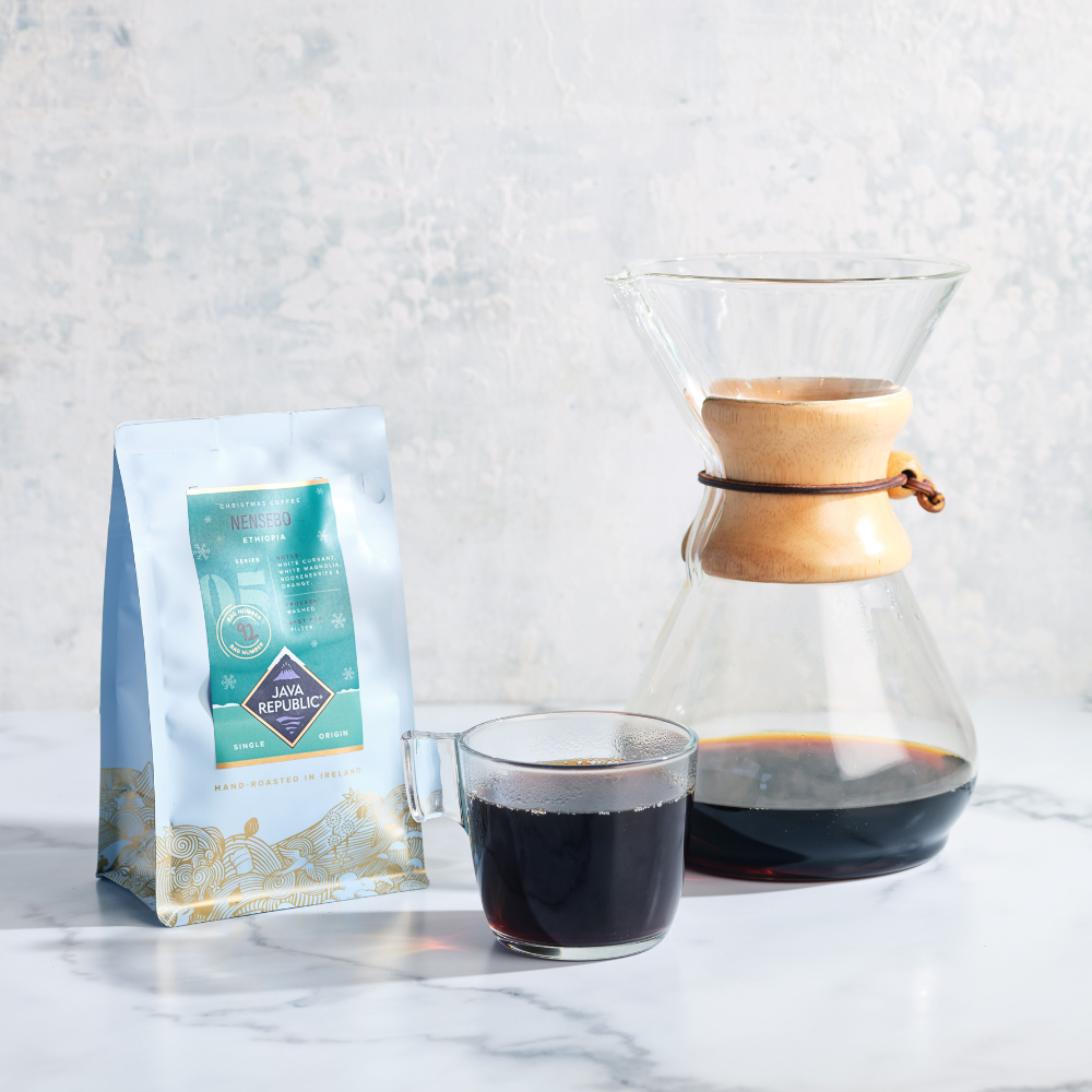 Nensebo Christmas Coffee Bag with a glass of filter coffee beside it and Chemex